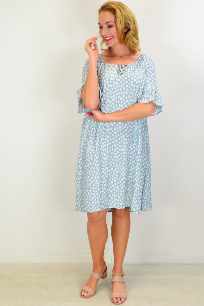 Hourglass spotted garden shift tunic dress displayed on a hanger, showcasing its relaxed fit and vibrant floral pattern.