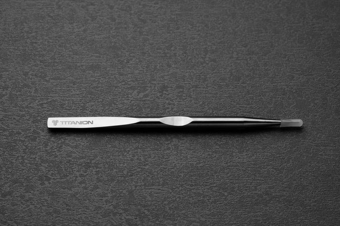 Metallic tweezer with "Titanion" branding on a textured gray background