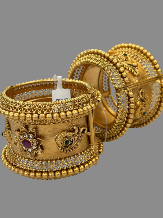 Kurti Connection USA ornate gold-tone bangle bracelets with peacock motifs, ruby and emerald stones, and filigree work.