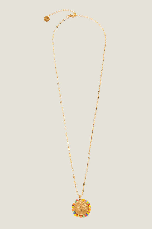 Product photo of the Aspiga Tuti Frutti Necklace, a gold necklace with a round palm tree pendant surrounded by multicolour beads