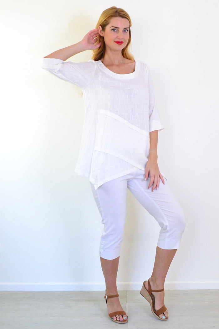 White layered linen blend tunic top by Ruby Rain, displayed on a hanger with visible layered design and lightweight fabric.