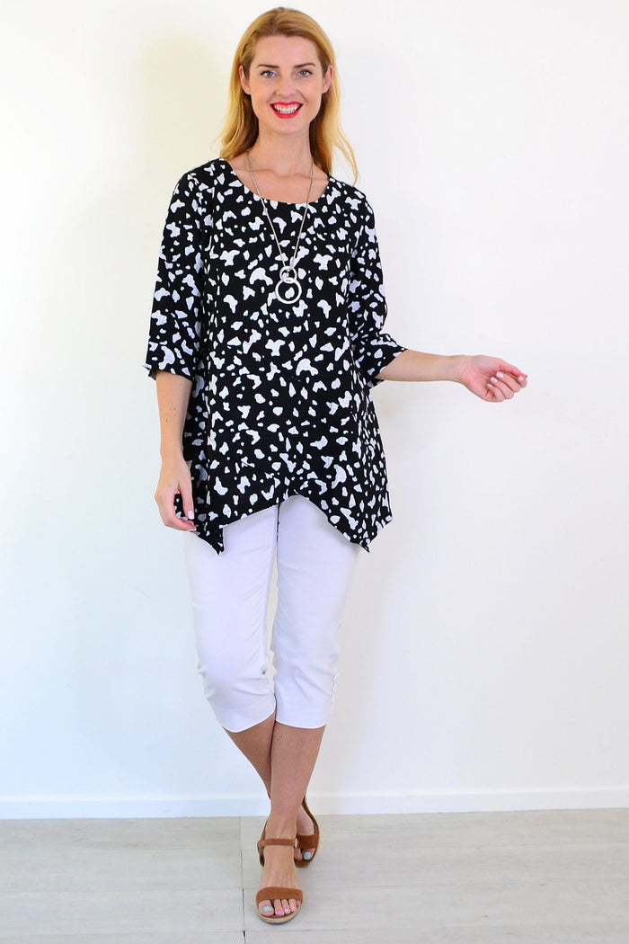 White paint splash linen blend tunic top by Ruby Rain, featuring a relaxed fit and artistic design, displayed on a hanger.