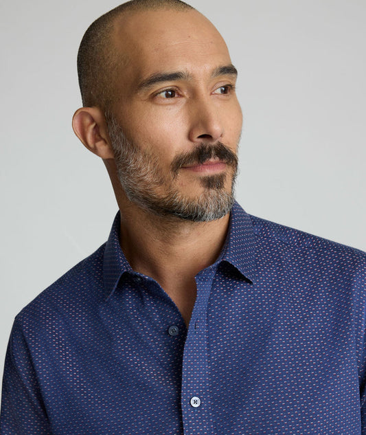 Model is wearing UNTUCKIt Rigby wrinkle-free shirt in navy print.