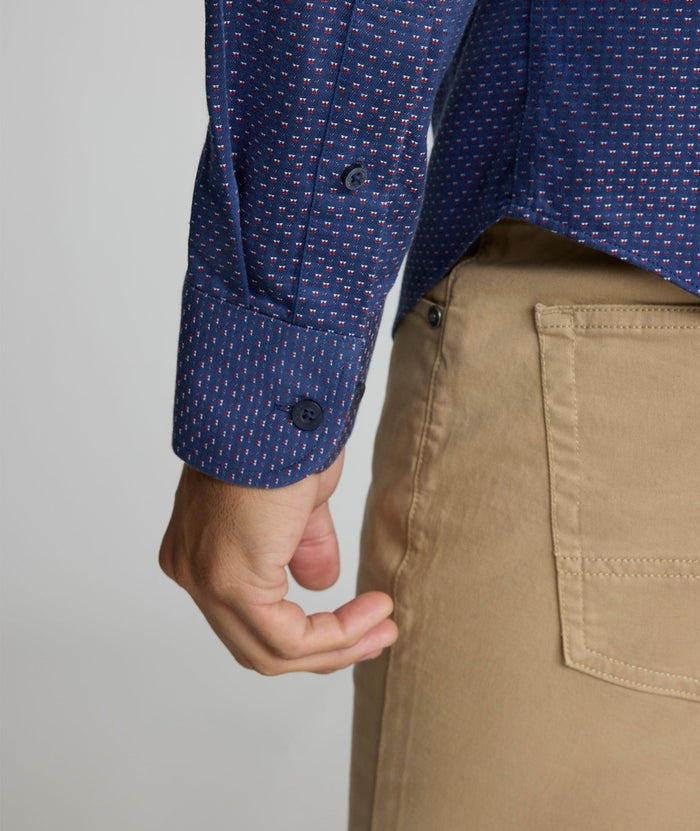 Model is wearing UNTUCKIt Rigby wrinkle-free shirt in navy print.